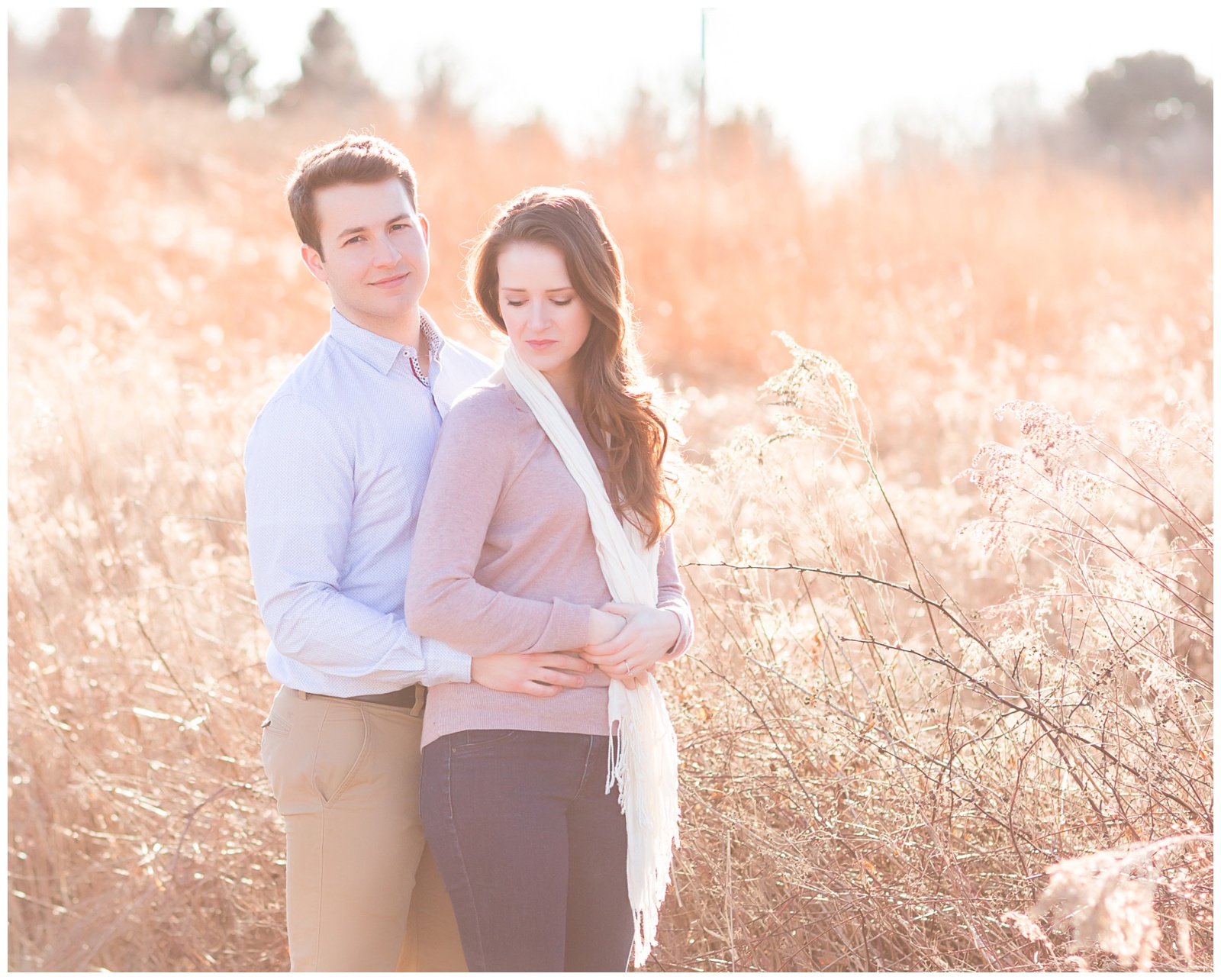 Couple standing in front of field of tall grass with glowy light