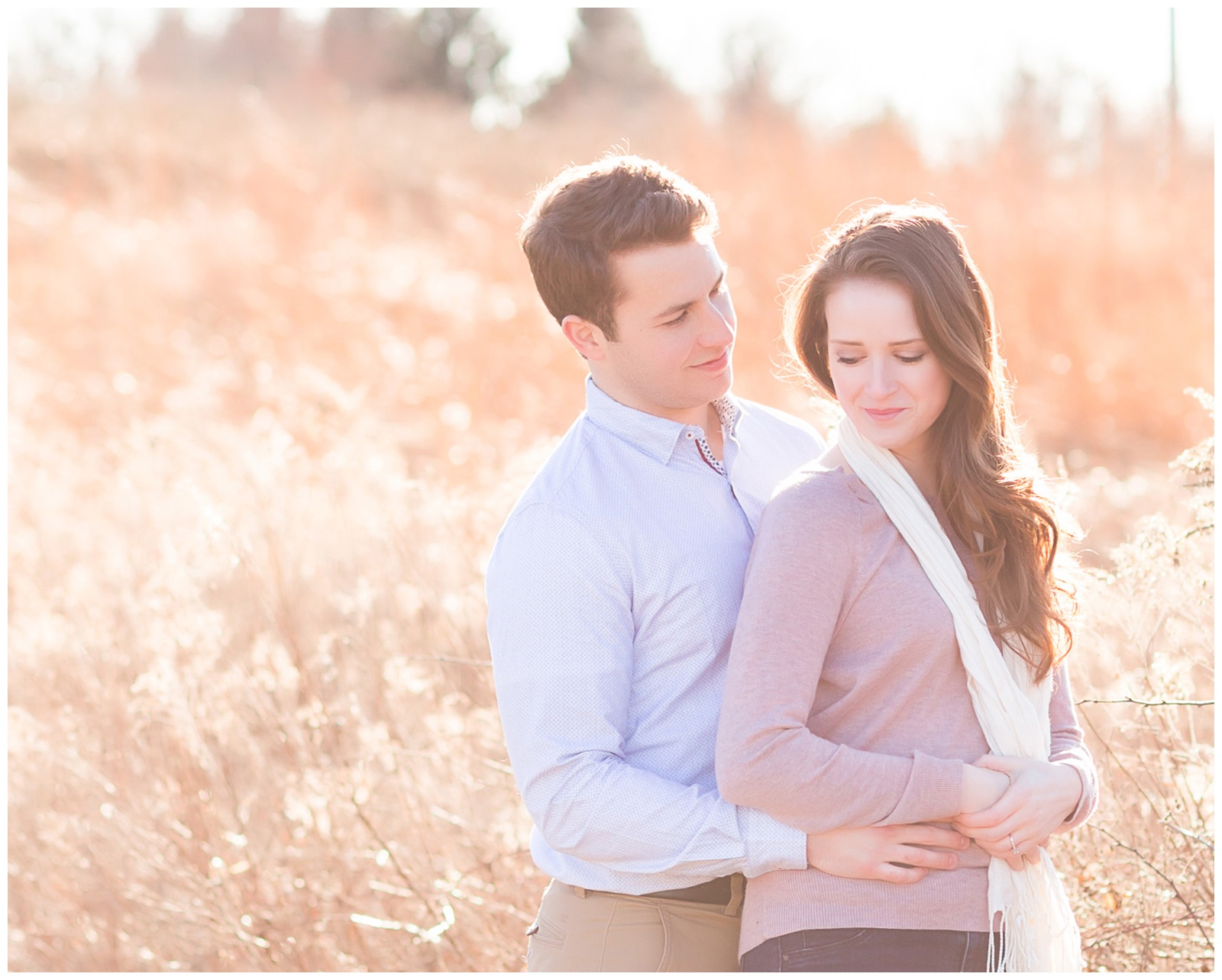 Couple standing in front of field of tall grass with glowy light