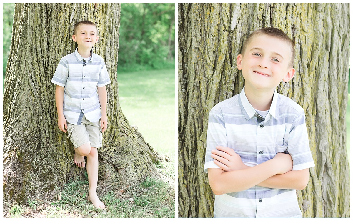 young boy leaning against tree