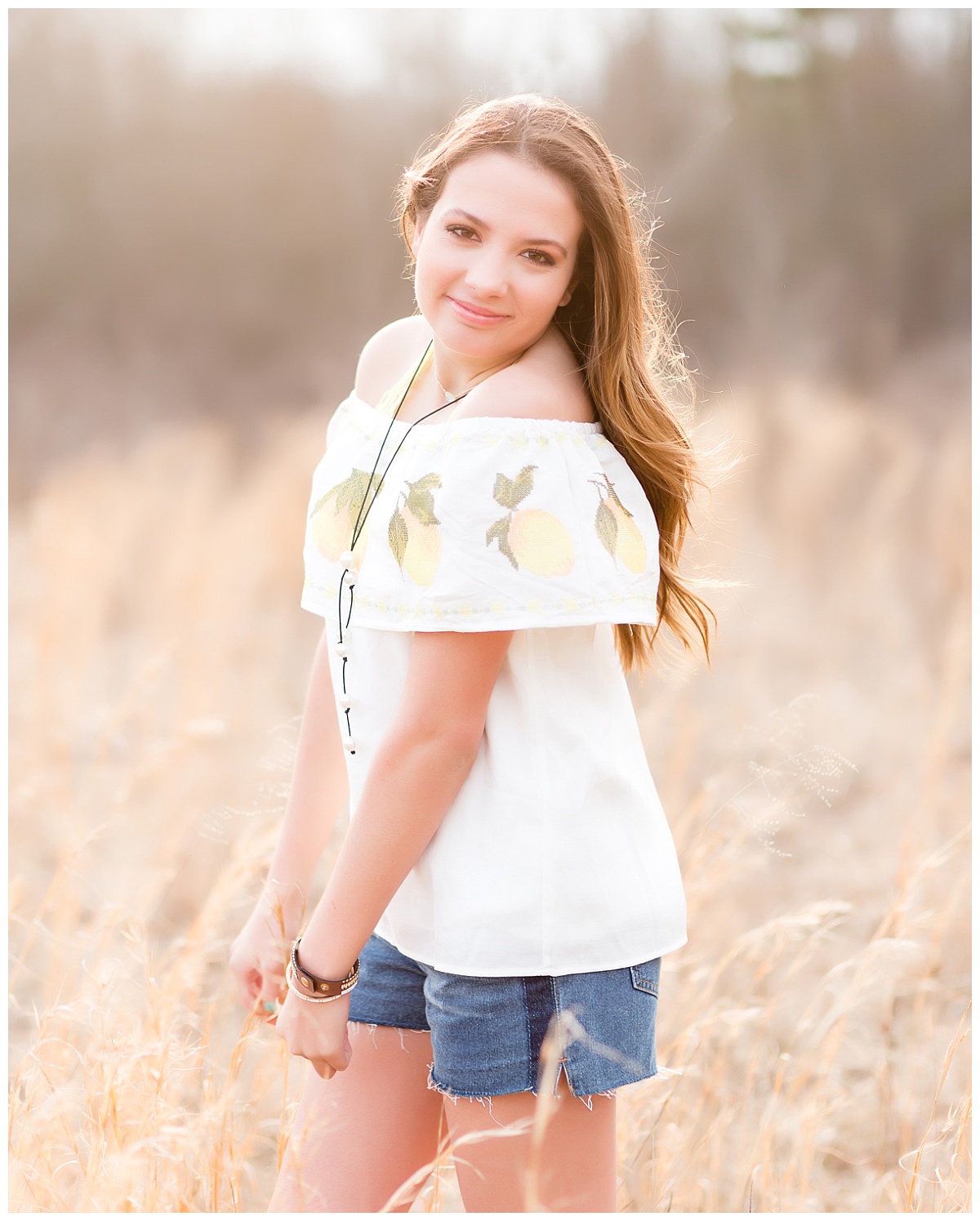 senior girl-3/4 length-standing in field of wheat colored grass