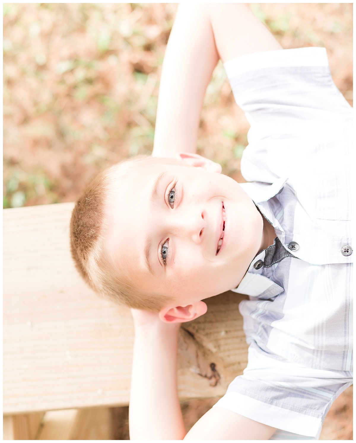young boy laying on picnic bench