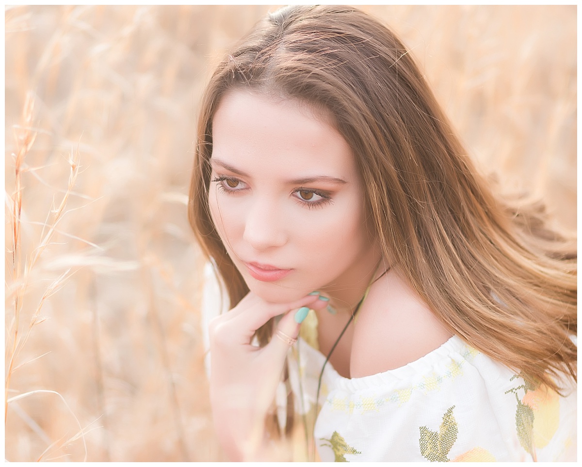 senior girl-squatting in field of wheat colored grass