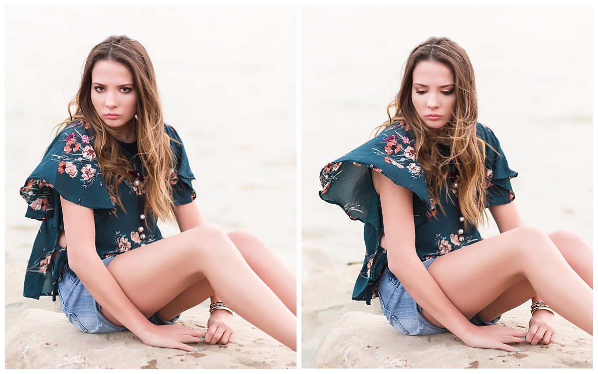 senior girl sitting on rocks near beach with serious expression