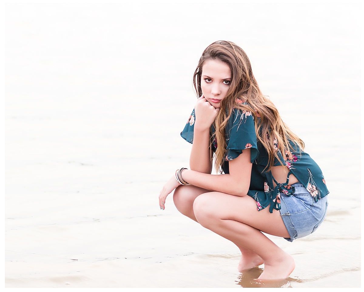 senior girl kneeling on shore
