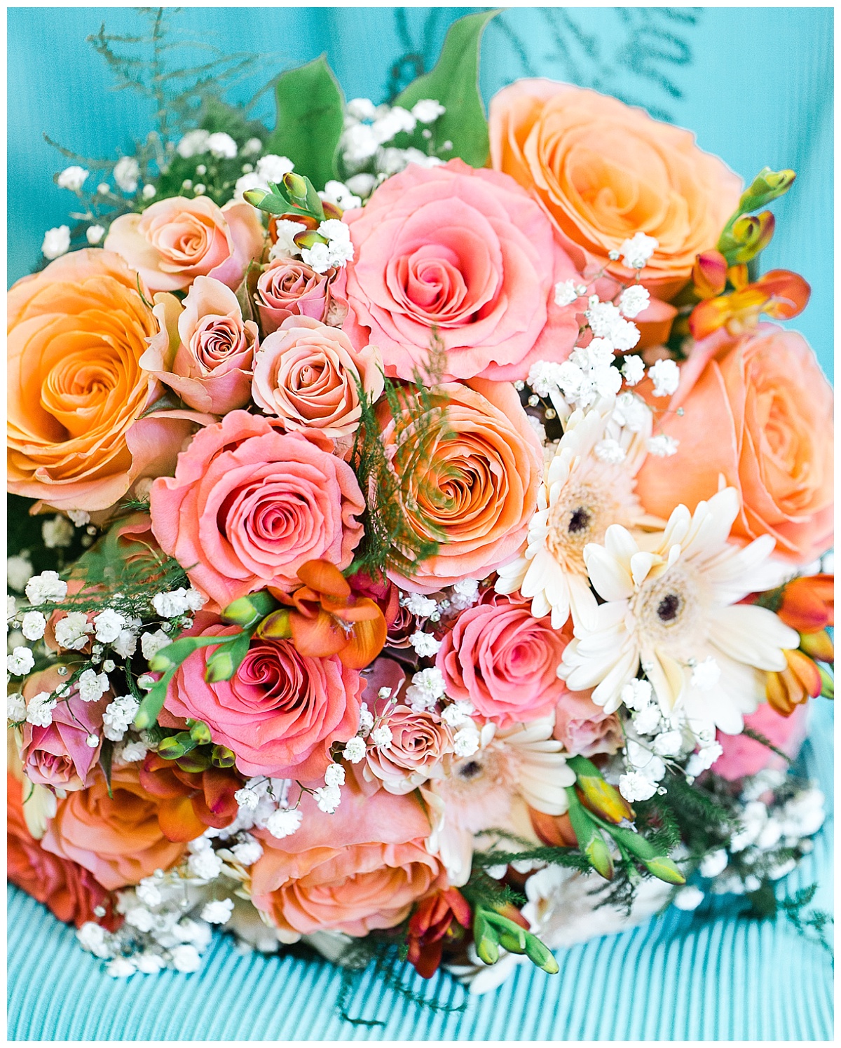 coral bouquet with baby's breath on teal dress