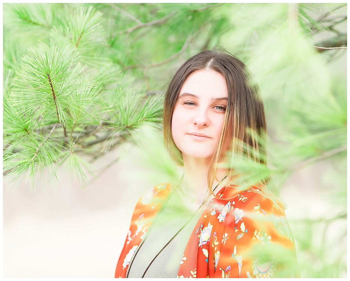 Senior girl near pine tree photo by Simply Seeking Photography
