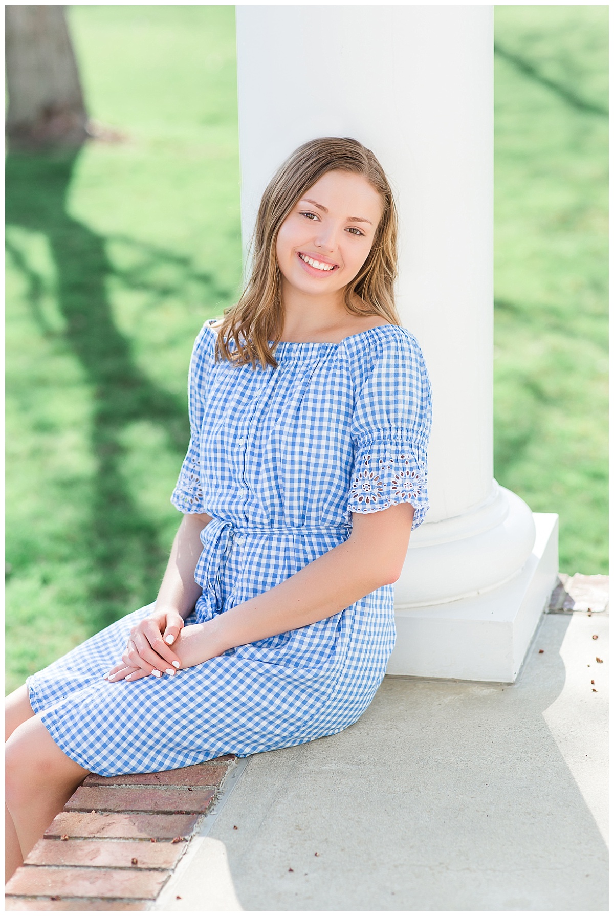 senior girl by white column of southern style porch