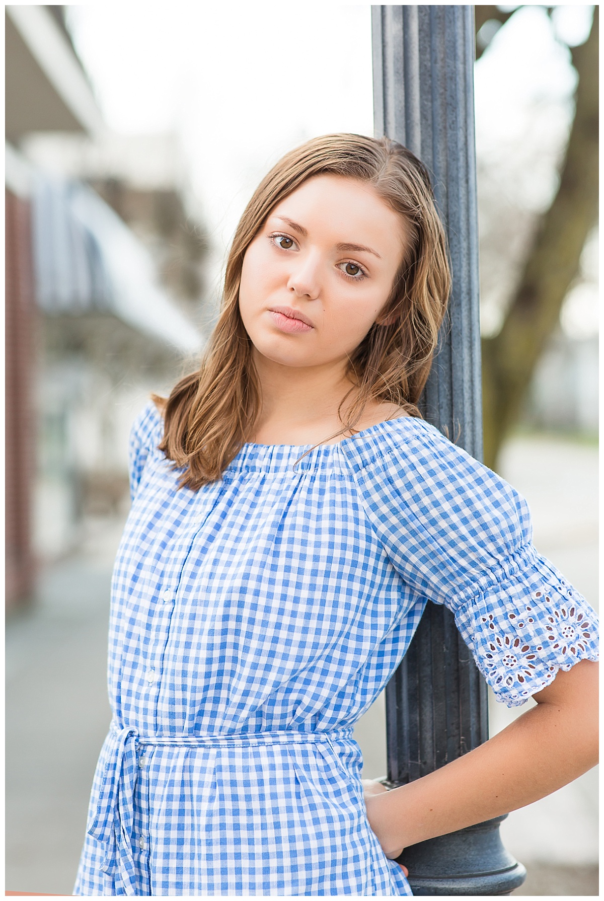 senior girl downtown by lamppost