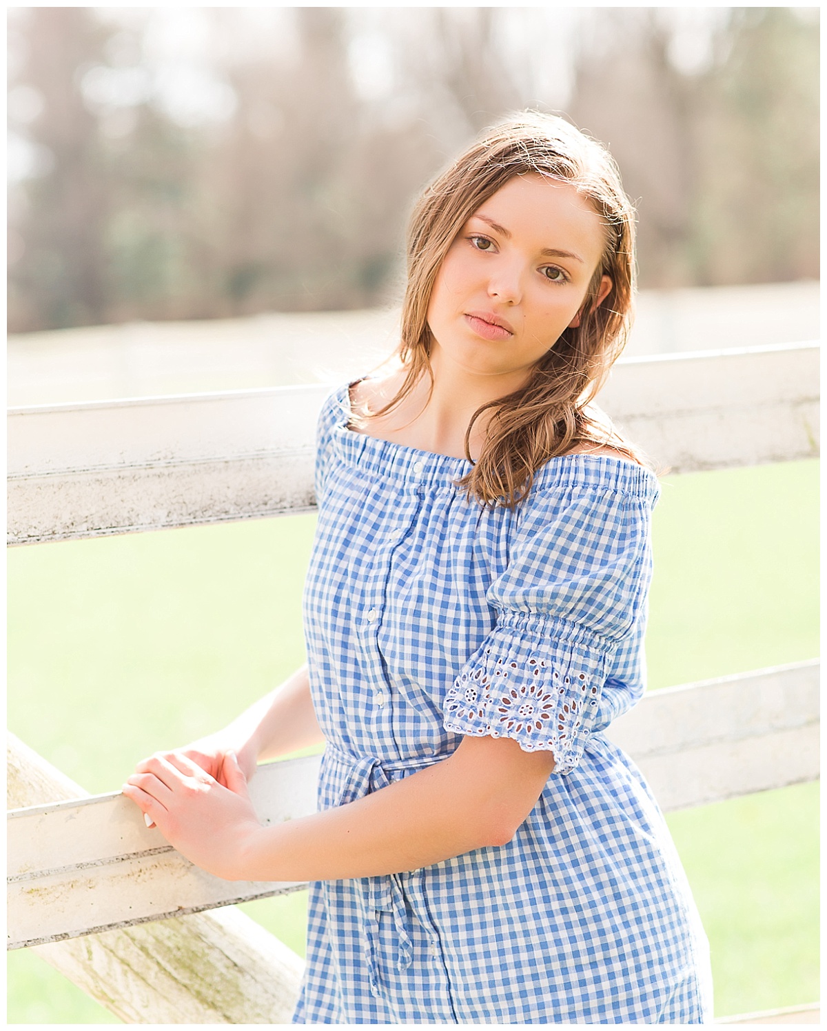 senior girl in front of white fence