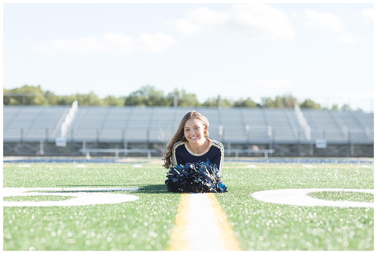 Senior cheerleader on football field photo by Simply Seeking Photography