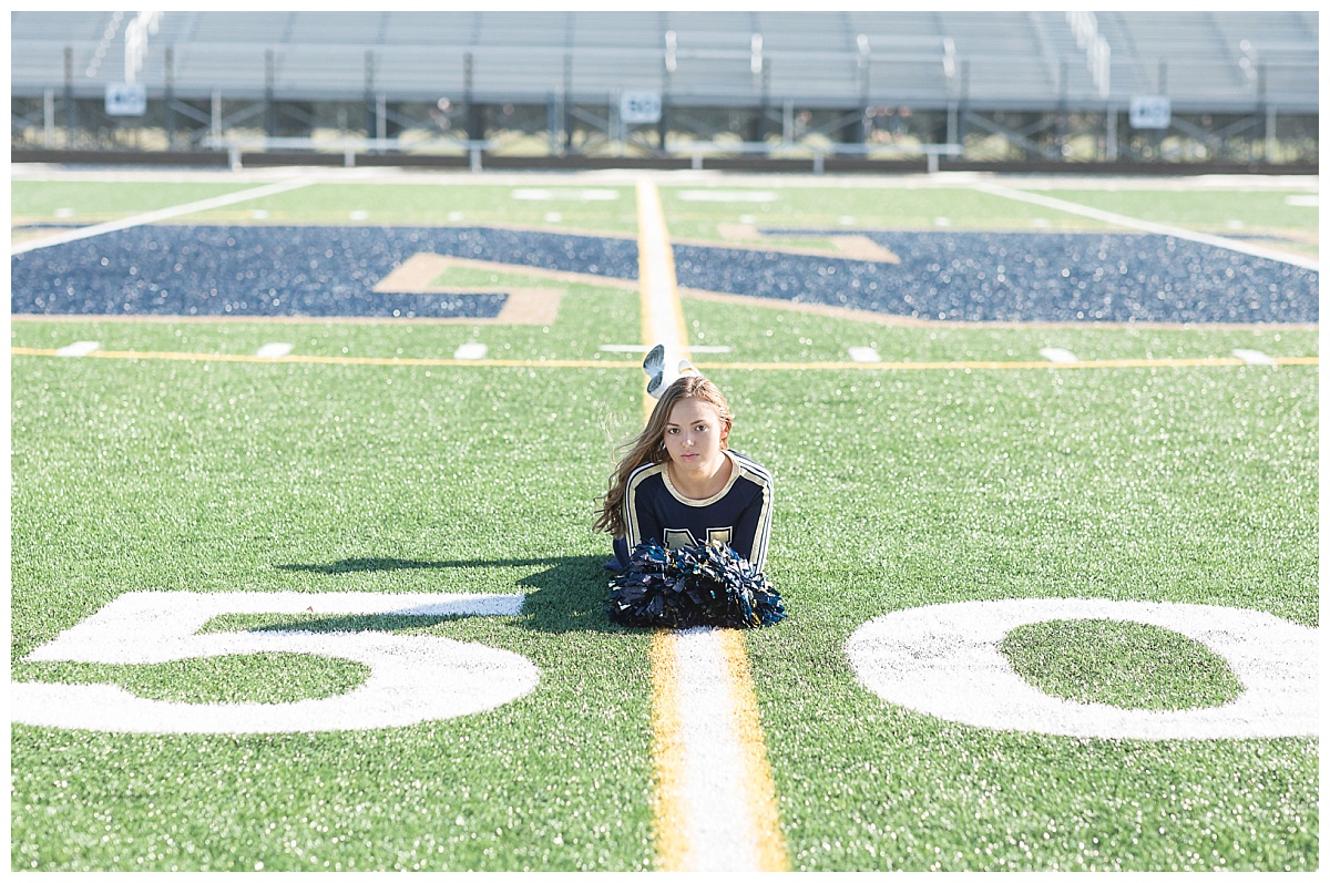 Senior cheerleader on football field photo by Simply Seeking Photography