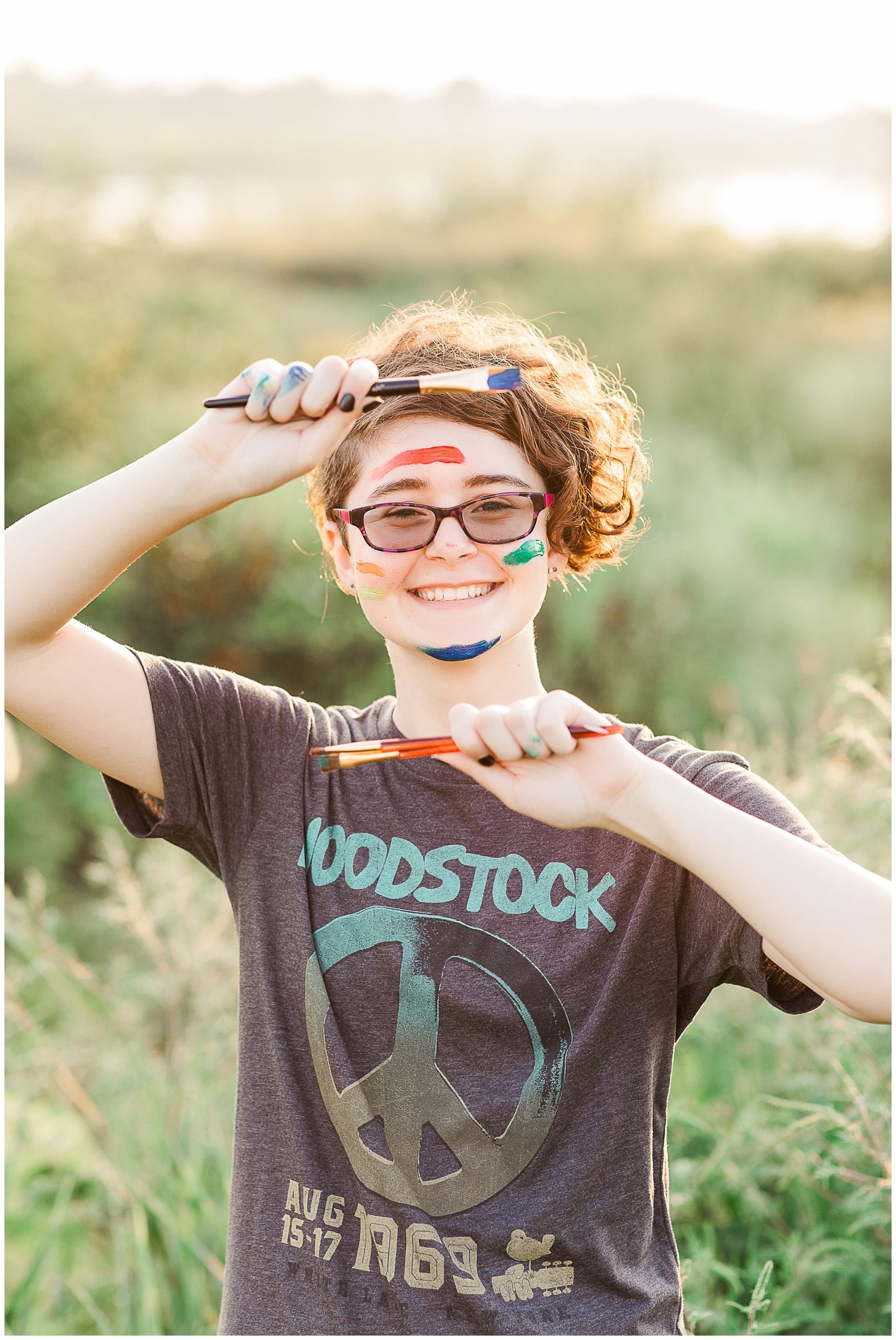 colorful senior session girl with painted hands and face