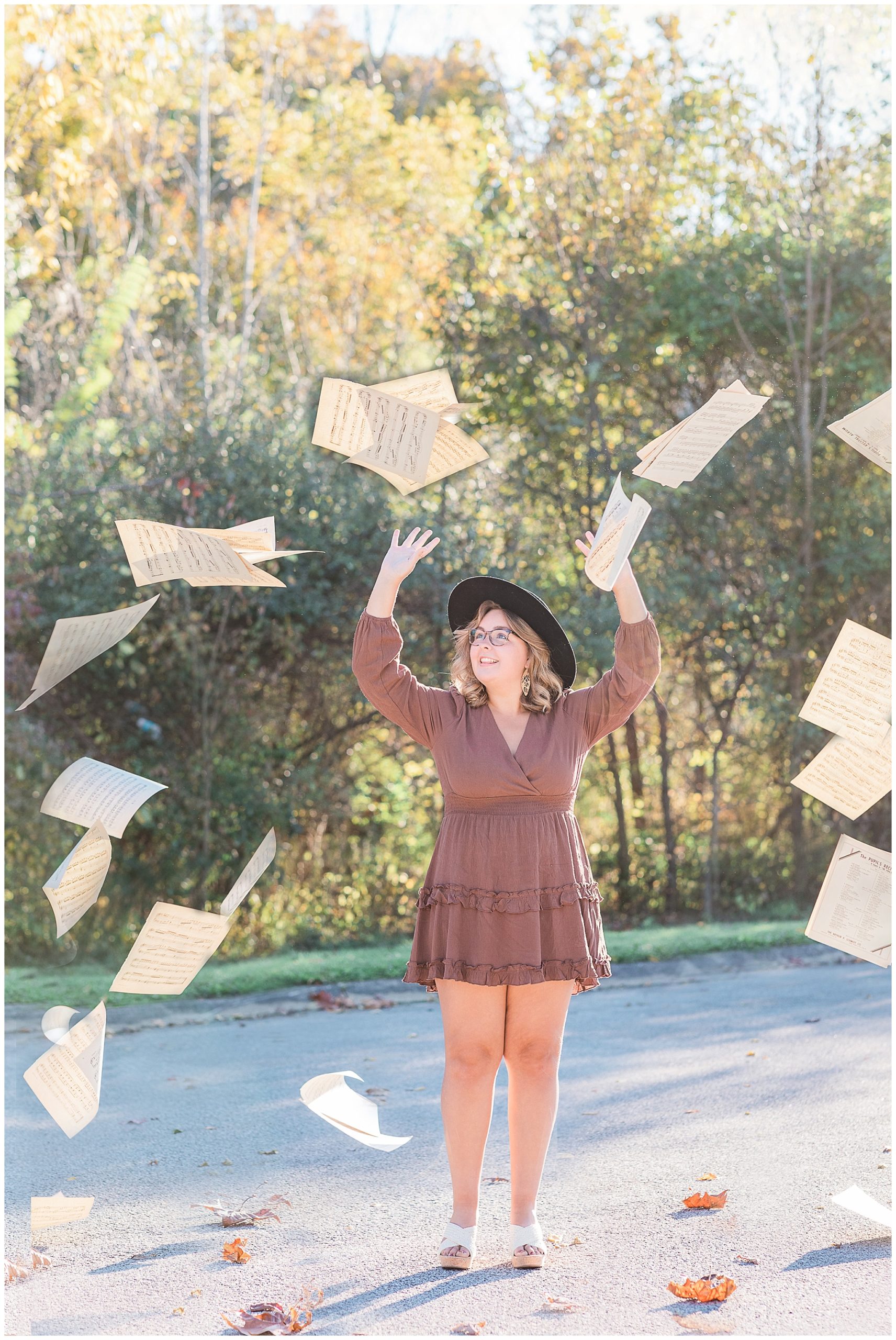 senior girl tossing music at boho senior session